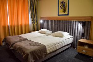 1 dormitorio con 1 cama grande con sábanas y almohadas blancas en Dnipro Hotel, en Cherkasy