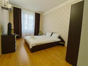 a bedroom with a bed and a television in it at Хотел Приятели in Vratsa