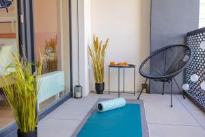 a room with a blue rug and a chair on a balcony at Design apartment • Balcony • Free Parking • Yoga • 10 mins to center in Prague