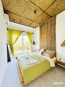 a bedroom with a large bed and a large window at PalmCalina - PhuQui Beach House in Cu Lao Thu
