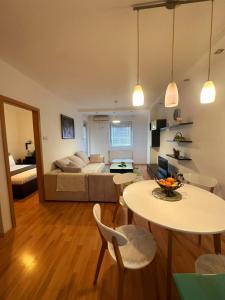 uma sala de estar com uma cama, uma mesa e cadeiras em Apartman Azra em Usje