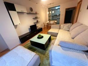 uma sala de estar com dois sofás brancos e uma mesa em Apartman Azra em Usje