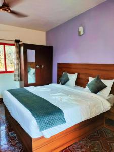a bedroom with a large bed with a purple wall at Calangute Beach Front in Calangute