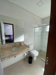 a bathroom with a sink and a toilet and a mirror at Flats Grangeiro in Crato