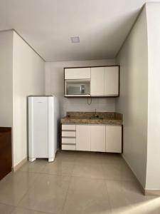 a kitchen with a refrigerator and a microwave at Flats Grangeiro in Crato