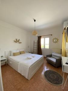 a bedroom with a large white bed and a couch at Olive House Apartment Paros in Kampos Paros