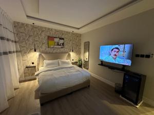 a bedroom with a bed and a flat screen tv at استديو فاخر بمنطقة مركزية in Riyadh