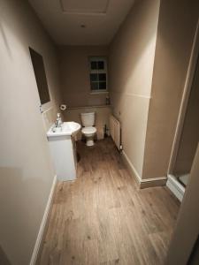 an empty bathroom with a toilet and a sink at The Fountain Hotel in Tuxford