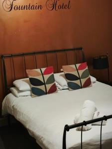 ein Bett mit Kissen darüber in der Unterkunft The Fountain Hotel in Tuxford