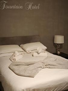Ein Bett oder Betten in einem Zimmer der Unterkunft The Fountain Hotel