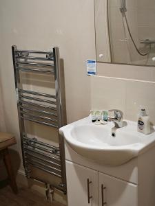 ein Bad mit einem Waschbecken und einem Spiegel in der Unterkunft The Fountain Hotel in Tuxford