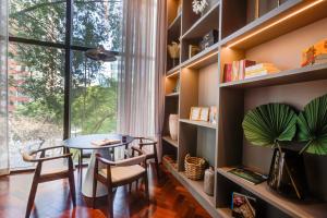 a dining room with a table and chairs and a large window at Qoya São Paulo Paulista, Curio Collection by Hilton in Sao Paulo