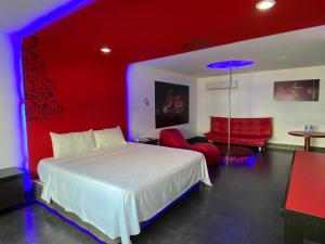 Autohotel Frances : غرفة نوم بسرير ابيض وجدار احمر