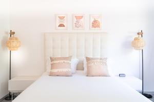 um quarto branco com uma cama branca com almofadas em Azul Hotel & Retreat em Playa Azul