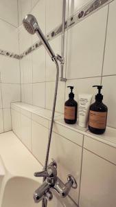 a bathroom with a shower head and two bottles of soap at Piz Alpina die grosse, moderne Wohnung mit Bergsicht in Davos