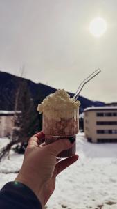 uma pessoa segurando um cupcake em sua mão em Piz Alpina die grosse, moderne Wohnung mit Bergsicht em Davos