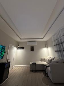 a white living room with a couch and a tv at استديو فاخر بمنطقة مركزية in Riyadh