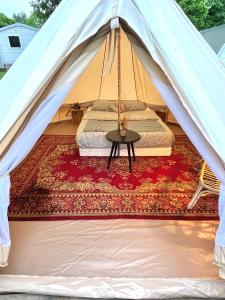 a tent with a bed and a table on a rug at Aparra Surfcamp Capbreton in Capbreton