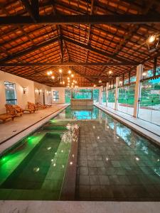 a swimming pool in a large building with a large ceiling at Hotel Pontal de Tiradentes in Tiradentes