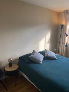 a bedroom with a blue bed with two pillows at Apartment in Montmartre in Paris