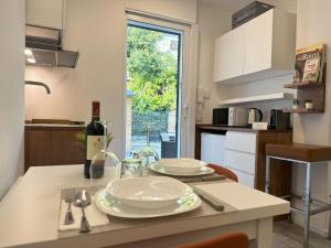 a kitchen with a table with plates and a bottle of wine at Monolatino Apartment in Rome