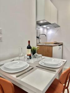 a table with two white plates and a bottle of wine at Monolatino Apartment in Rome