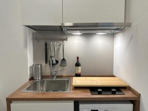a kitchen with a sink and a bottle of wine at Monolatino Apartment in Rome