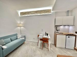 a living room with a blue couch and a kitchen at Monolatino Apartment in Rome