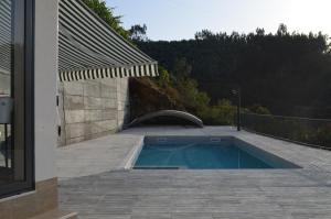 a swimming pool on a patio next to a house at Casa de Campo de SOUTELO in Soutelo