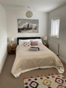 a bedroom with a large bed with two lamps and a rug at Five Farthings Stylish cottage in Littleworth