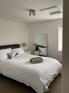 a white bedroom with a large white bed in it at Five Farthings Stylish cottage in Littleworth