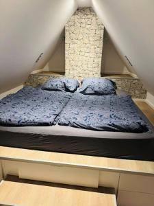 um quarto com uma cama com cobertores e almofadas azuis em Schöne Dachgeschosswohnung im Zentrum Erkelenz mit Parkplatz em Erkelenz