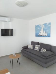 a living room with a couch and a sail boat at Apartments Bucića Dvori in Starigrad-Paklenica