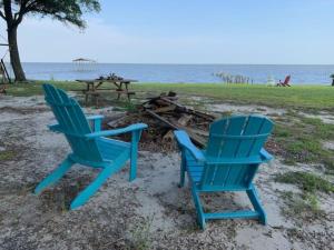 海泉市的住宿－At Ease，海滩上的两张蓝色椅子和一张野餐桌