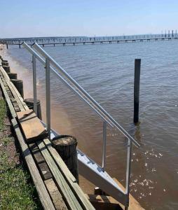 a dock with a metal railing in the water at At Ease in Ocean Springs