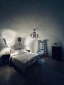 - une chambre avec un grand lit et un lustre dans l'établissement Luxury Villa Amore di Montagna, à Calvo