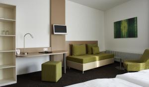 ein Hotelzimmer mit einem Bett, einem Schreibtisch und einem Stuhl in der Unterkunft Hotel Feyrer in Senden