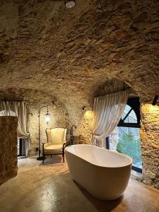 La salle de bains est pourvue d'une grande baignoire et d'un mur en pierre. dans l'établissement Luxury Villa Amore di Montagna, à Calvo