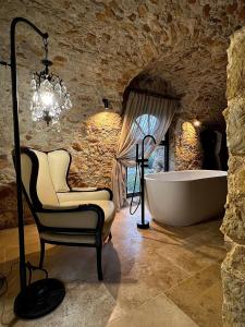 La salle de bains est pourvue d'une chaise et d'une baignoire. dans l'établissement Luxury Villa Amore di Montagna, à Calvo