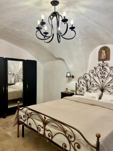 - une chambre avec un grand lit et un lustre dans l'établissement Luxury Villa Amore di Montagna, à Calvo