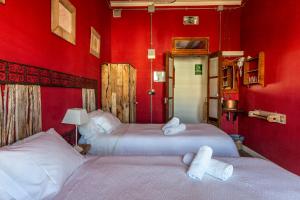 two beds in a room with red walls at Ibiza Boutique Guest House in Ibiza Town