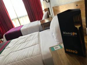 um quarto de hotel com uma cama com um menu em Hotel El Morlaco em Cuenca