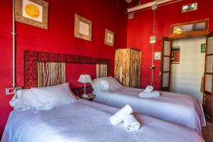 two beds in a room with red walls at Ibiza Boutique Guest House in Ibiza Town