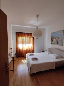 Un dormitorio con una gran cama blanca y una ventana en Spacious garden house, Orebić (4+1) en Orebić