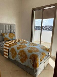 Panoramique appartement في القنيطرة: غرفة نوم بسرير ونافذة كبيرة