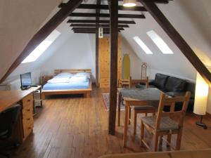 ザールブリュッケンにあるFerienwohnung Am Homburg Nr 1のベッドとダイニングテーブル付きの屋根裏部屋