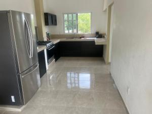 a kitchen with a stainless steel refrigerator and a sink at Hotel y Bungalows Bugambilias in San Patricio Melaque