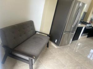 a chair in a kitchen with a refrigerator at Hotel y Bungalows Bugambilias in San Patricio Melaque