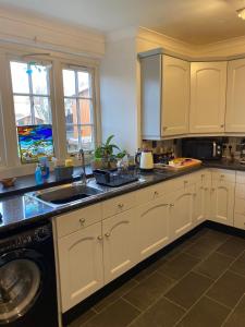a kitchen with white cabinets and a sink at Dreel Cottage in Anstruther