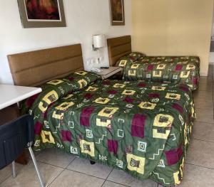 a hotel room with two beds and a table at Hotel las Palmas in Hermosillo